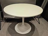 the table is white and has a black chair in front of it