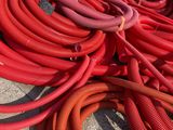 a pile of red and yellow hoses on the ground