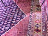 a cat that is sitting on a rug on the floor