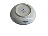 a white bowl with blue designs on it on a white surface