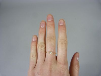 a woman ' s hand with a gold ring on it