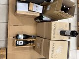 Plusieurs caisses de vin sont empilées les unes sur les autres dans une pièce