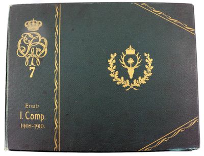 un livre vert orné d'une bordure dorée et d'une couronne