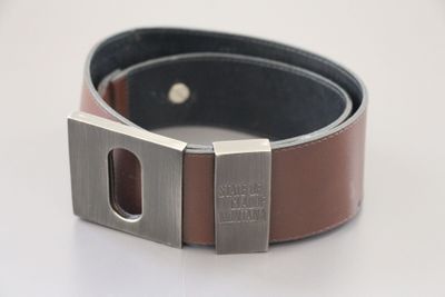 leather belt with metal buckle on white background