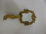un miroir ancien avec un cadre doré posé sur un fond blanc