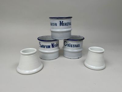 trois vases blancs bordés de bleu, posés sur une surface blanche