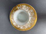 a yellow and white cup and saucer sitting on a table