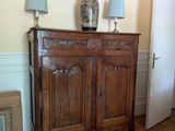 une armoire en bois surmontée de deux lampes