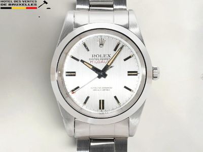 une photo d'une montre Rolex à cadran blanc montée sur un bracelet
