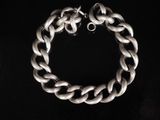 un gros plan d'un bracelet à chaîne argentée sur fond noir