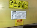 a sign on the side of a yellow wall that says caution
