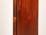 a tall wooden cabinet with a door on top of it
