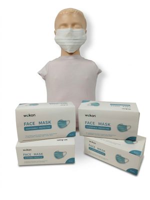 trois boîtes de masques faciaux et une tête de mannequin sur fond blanc