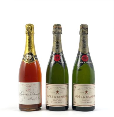 trois bouteilles de champagne sont alignées sur une surface blanche