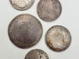 cinq types différents de pièces d'argent sur un fond blanc