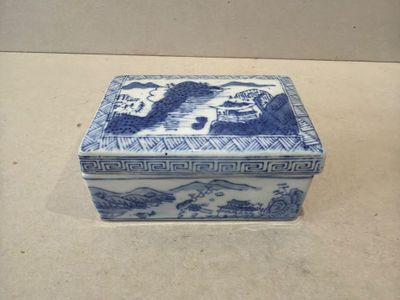 une petite boîte bleue et blanche posée sur une table