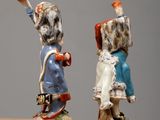 two figurines of a man and a woman on a bench