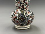 un vase orné d'un motif paisley, posé sur une table