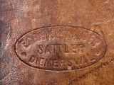 an image of a brown leather bag with a label on it