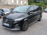 Le monospace Mercedes noir est garé sur le bord de la route.