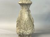 a stone vase that is sitting on a white surface