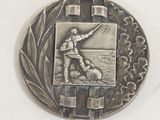 a silver medal with a picture of a man on it