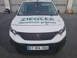 une camionnette blanche garée devant un bâtiment