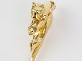 a close up of a gold plated piece of jewelry on a white surface
