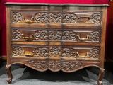 une commode en bois dans une pièce aux murs rouges