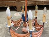 a chandelier made out of copper pipes on the ground