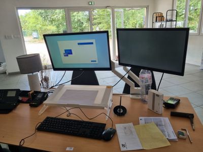 un bureau sur lequel sont posés deux écrans d'ordinateur et un clavier