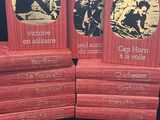 trois livres rouges empilés les uns sur les autres sur une table
