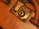 a close up of a brown suitcase with a lock on it