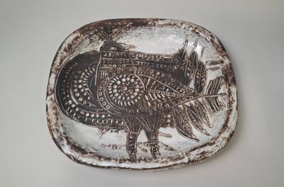 a brown and white plate with a picture of a bird on it