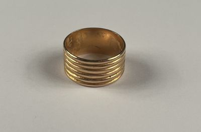 gros plan d'une bague en or sur une surface blanche