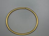 a close up of a gold bracelet on a gray surface