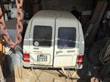 a white van parked in a garage with a chain hanging from it ' s side
