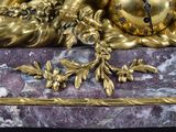 a gold clock sitting on top of a marble table