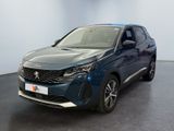 La voiture bleue est garée dans une grande pièce au sol noir.