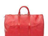 a red duffel bag sitting on top of a white surface