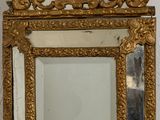 un miroir doré accroché au mur, avec un cadre doré