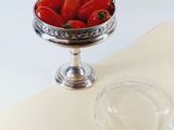a bowl of tomatoes sitting on a table next to a bowl of strawberries
