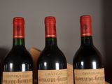 three bottles of red wine are lined up on a table