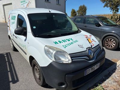 une camionnette blanche garée sur un parking à côté d'un bâtiment