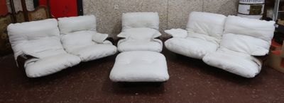 three white reclining chairs and a ottoman in a room with a wallpapered wall