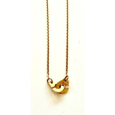 gros plan d'un collier en or sur fond blanc