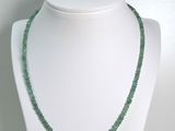 collier composé de perles de verre vertes sur un mannequin blanc