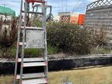 une échelle posée par terre à côté d'un immeuble