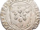 un gros plan d'une pièce d'argent sur laquelle figure un blason