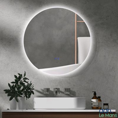 the bathroom vanity has a round mirror above it and a plant